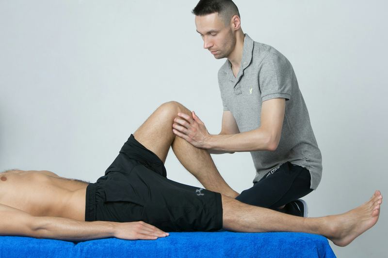 Physiotherapist examining a patient's knee